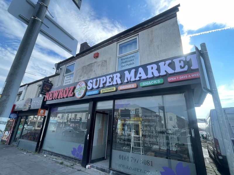 Large illuminated Newroz Supermarket shopfront under a blue sky